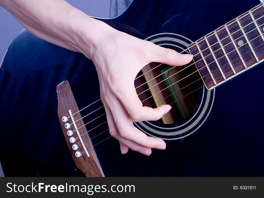 Male hand with classical antique wooden guitar