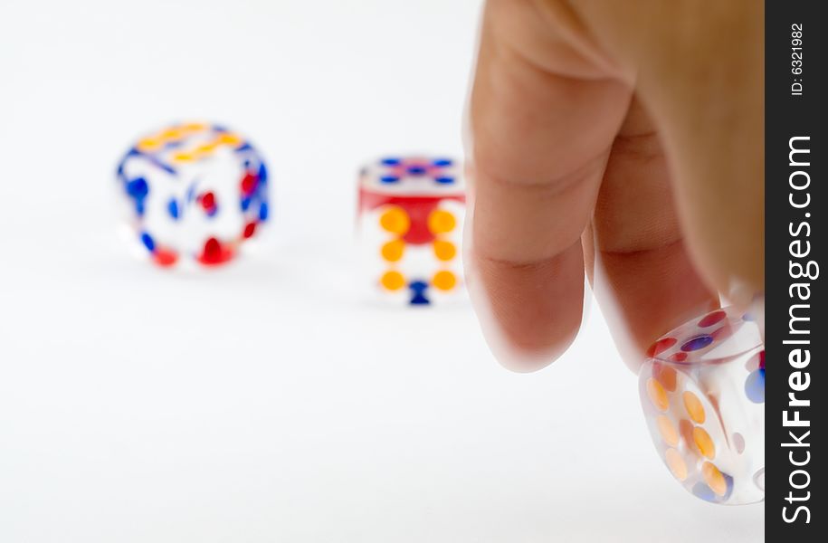 Hand rolling a dice against two thrown dice. Hand rolling a dice against two thrown dice