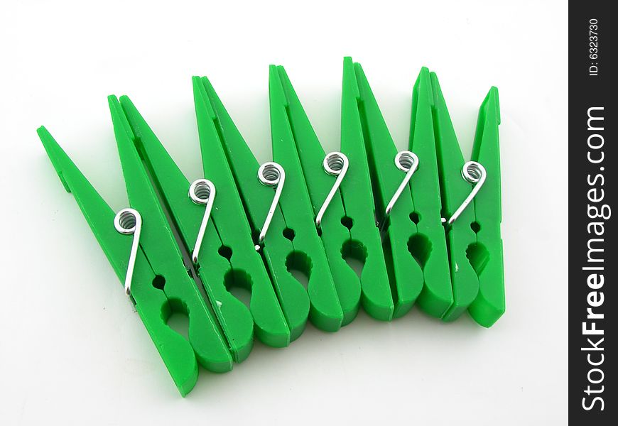 Green clothes-pegs isolated over white background.