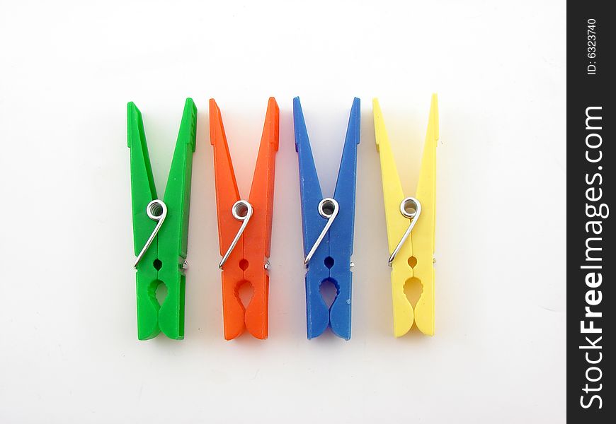 Green, red, blue and yellow clothes-pegs isolated over white background.