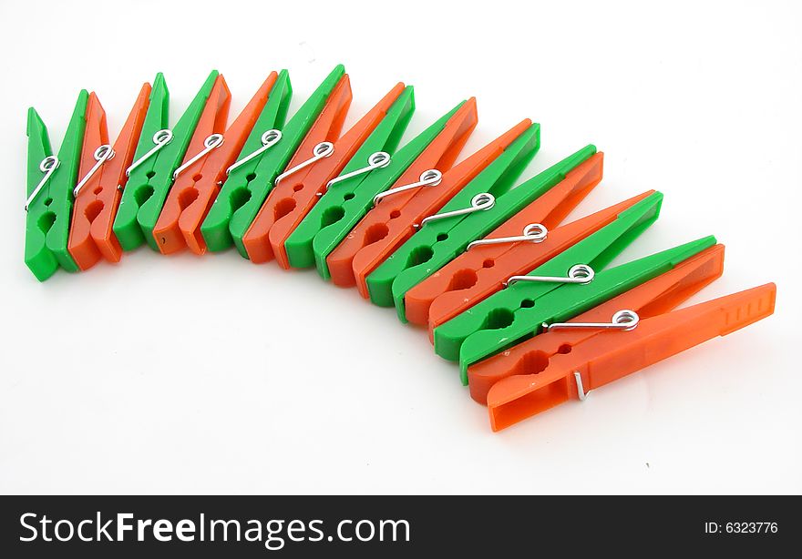 Green and red clothes-pegs isolated over white background.