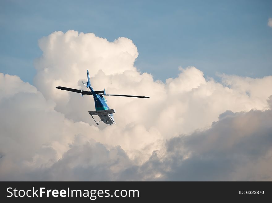 Helicopter flying off into the clouds