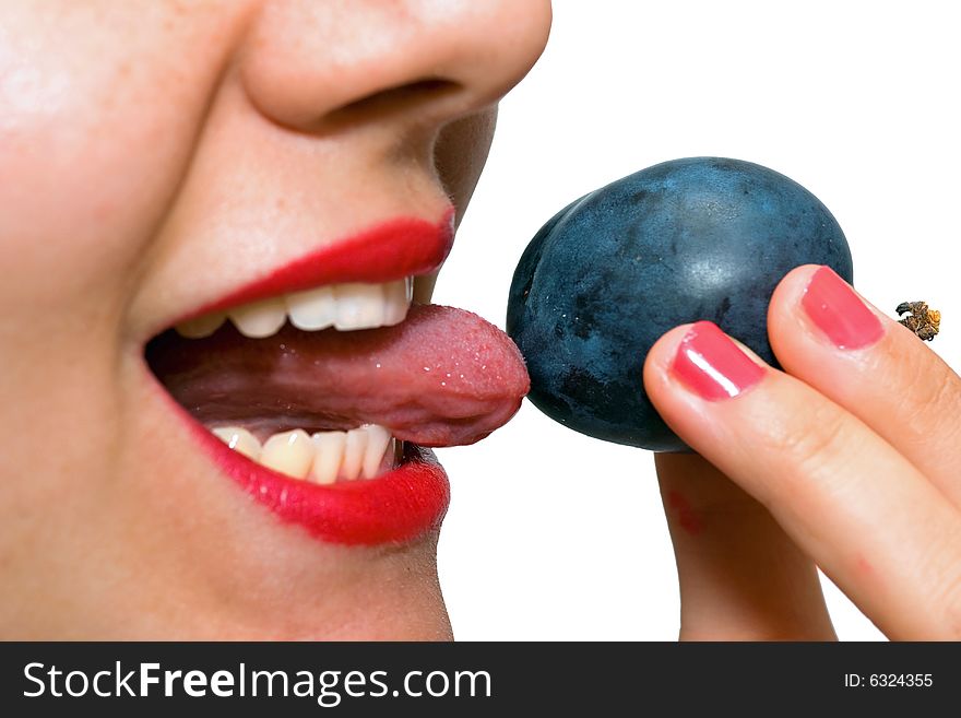 Girl, holding a plum on the tip of her tongue, just before taking a bite. Girl, holding a plum on the tip of her tongue, just before taking a bite