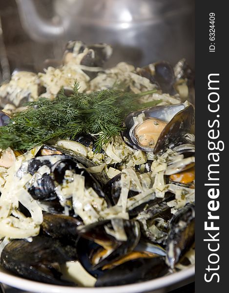 Freshly cooked black mussels, still in the shell, presented in a bowl with delicious cream dressing and garnish. Freshly cooked black mussels, still in the shell, presented in a bowl with delicious cream dressing and garnish.