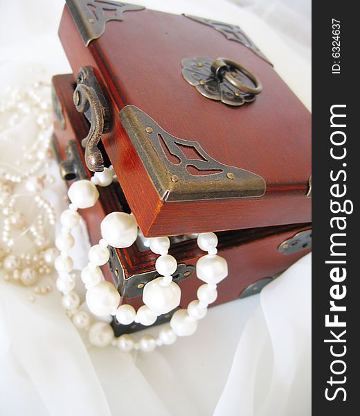 Casket of of pearl necklace on white material. Casket of of pearl necklace on white material