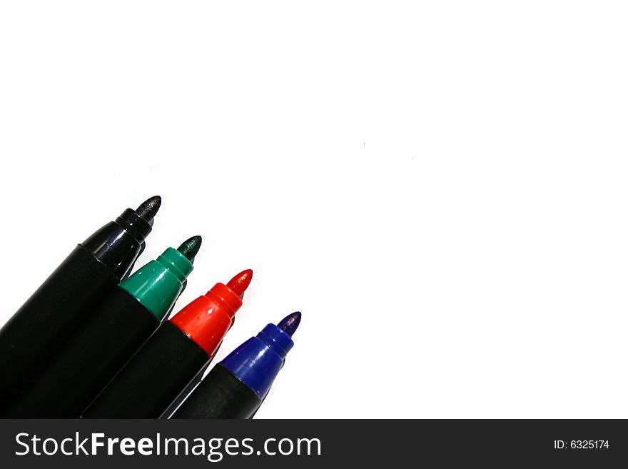 An image of four different color markers over white