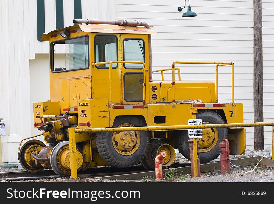 A larg yellow railroad track utility vehicle. A larg yellow railroad track utility vehicle