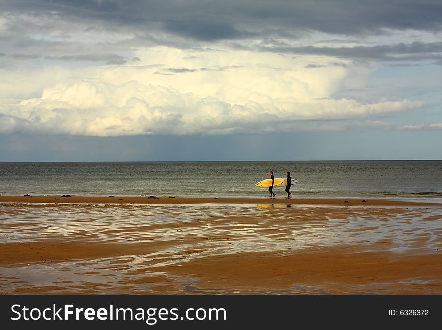 Young people with surfing boat waking along the sea. Young people with surfing boat waking along the sea.