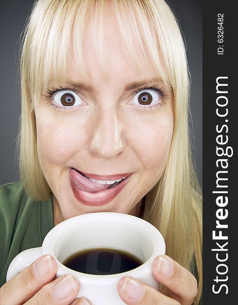 Beautiful Woman Enjoys Her Coffee Against a Grey Background. Beautiful Woman Enjoys Her Coffee Against a Grey Background.