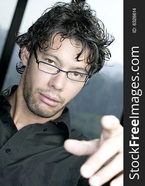 Young man with glasses pointing at the camera. Young man with glasses pointing at the camera