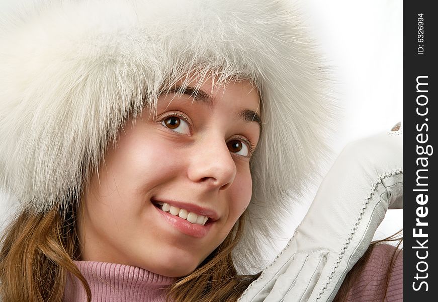 Beauty girl teenager in white fur cap.