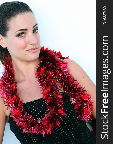 Isolated Christmas portrait of a pretty woman decorated with tinsel.