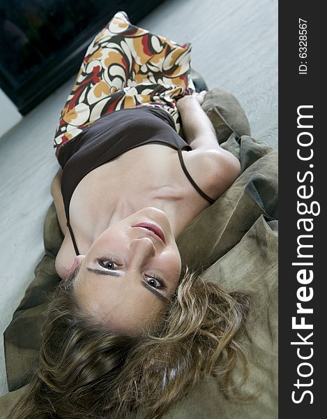 Picture of young, serious looking woman lying on the floor. Picture of young, serious looking woman lying on the floor