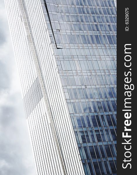Modern high glass business center's wall wtih dramatci sky reflections