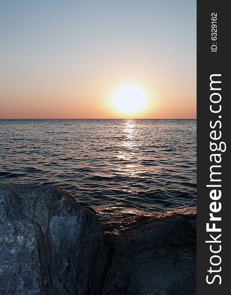 Sea sunset with sun and stones