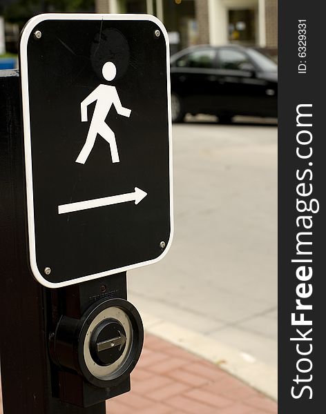 Black & white metal street crossing sign affixed to a light post