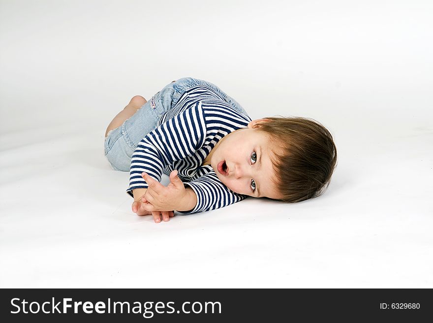 Child  in sailor's striped vest lying down isolated on white