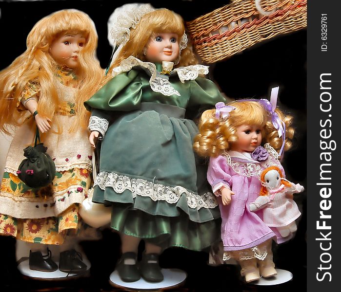 Still of collectible porcelain doll display with bounce and fill and background replaced; and their little basket hanging by them; one holding her own babydoll, one holding purse; a very small part of my wifes extensive collection. one wears green outfit; one dressed in purple doll clothes and one in a white print. Something that might interest doll collectors and doll magazines.