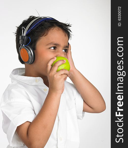 Asian boy biting into a green apple