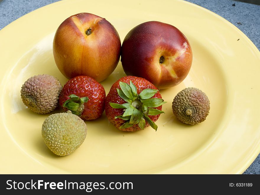 Nectarines, strawberries and lychees on a plate. Nectarines, strawberries and lychees on a plate