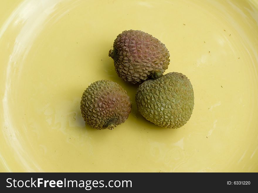 Image of a group of lychee's on a yellow plate