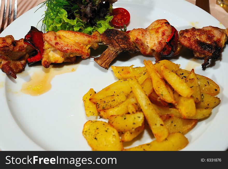 Grilled chicken with potato and mushrooms focus on chicken