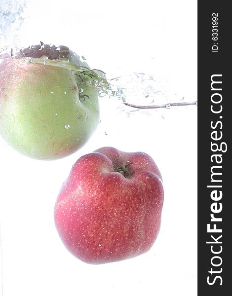 Red apple and green apple splash in water