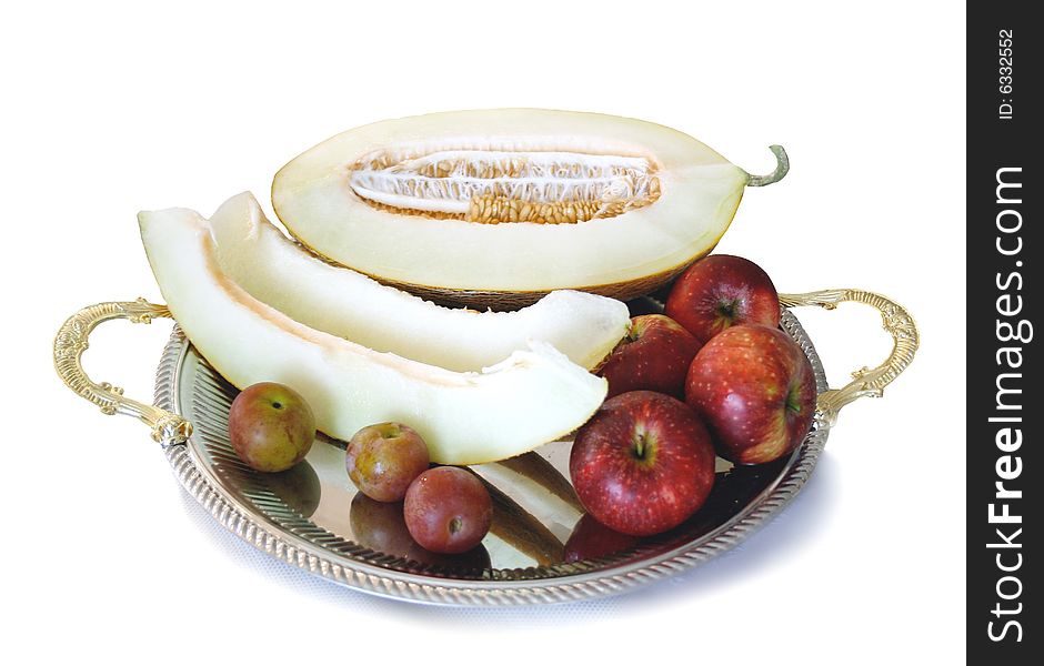 Segments of melon, plums and apples on tray. Segments of melon, plums and apples on tray