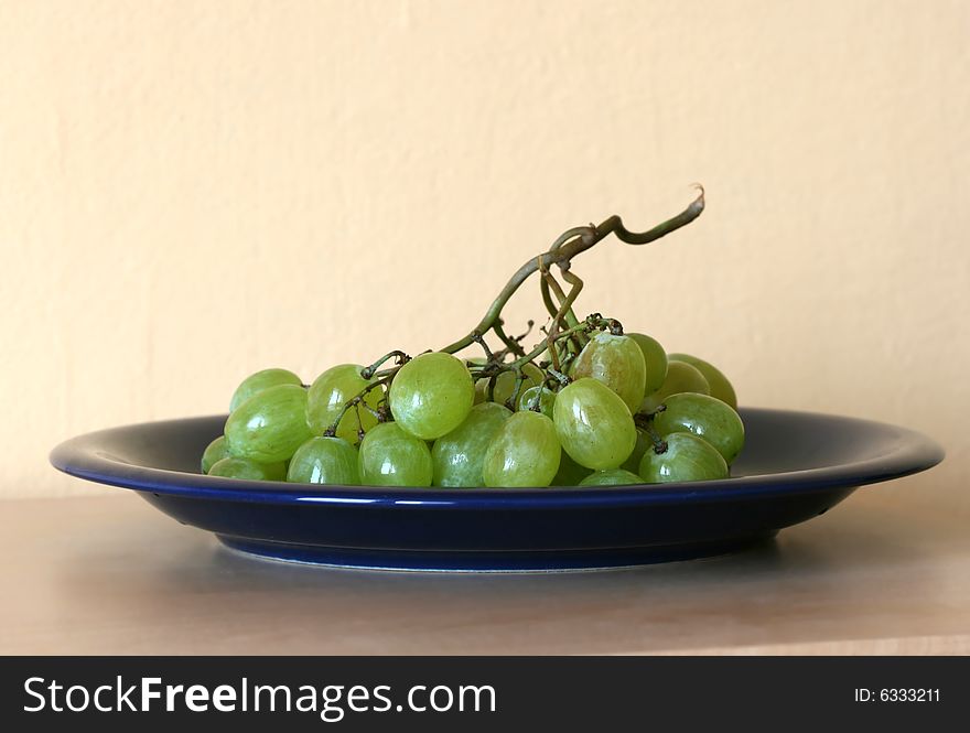 Green grape-vine on blue plate. Green grape-vine on blue plate