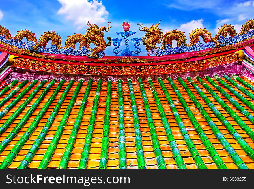 The colorful dragon roof in the chainese style temple in Ayudhaya temple , the bright sky and greeny ceramic bamboo with the 2 dragon make the picture so interesting. The colorful dragon roof in the chainese style temple in Ayudhaya temple , the bright sky and greeny ceramic bamboo with the 2 dragon make the picture so interesting