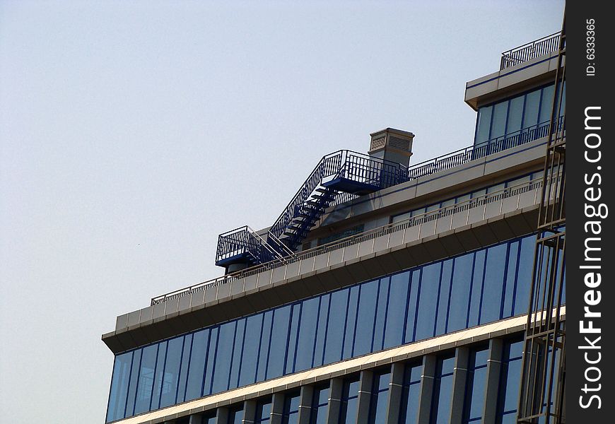 Part of building. Glass facade. Pipe and stair on a roof. Part of building. Glass facade. Pipe and stair on a roof.