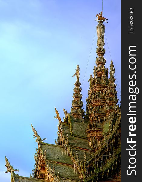 In Thailand in the city of Pattaya the sanctuary of truth is a wooden construction high of 105 meter covered with wooden carved sculpture; view of the sculpted roof. In Thailand in the city of Pattaya the sanctuary of truth is a wooden construction high of 105 meter covered with wooden carved sculpture; view of the sculpted roof