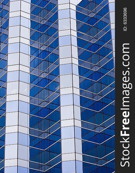 A tall modern skyscraper of blue and grey glass. A tall modern skyscraper of blue and grey glass