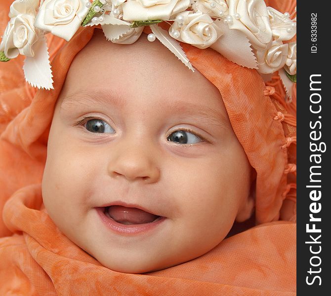 Little baby wrapped in orange shawl