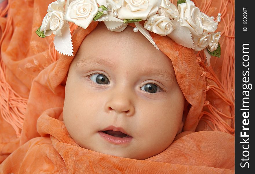 Little baby wrapped in orange shawl