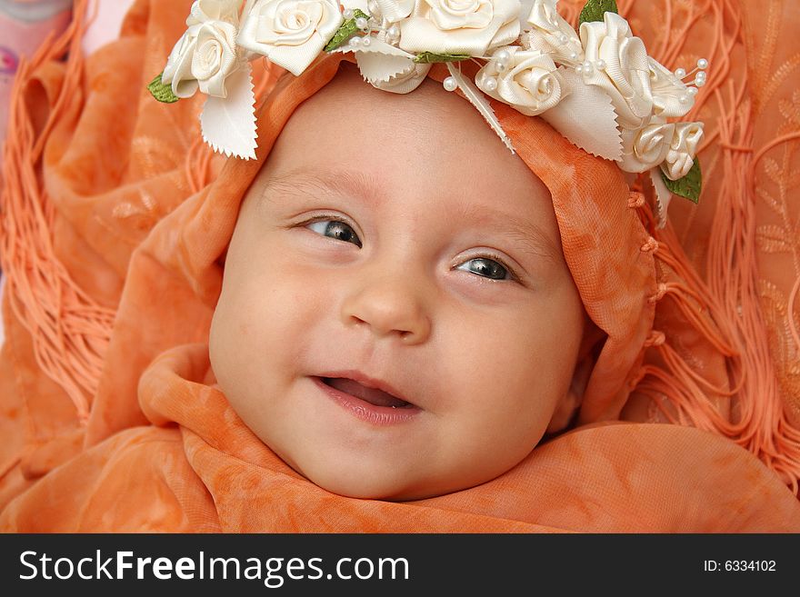 Little baby wrapped in orange shawl