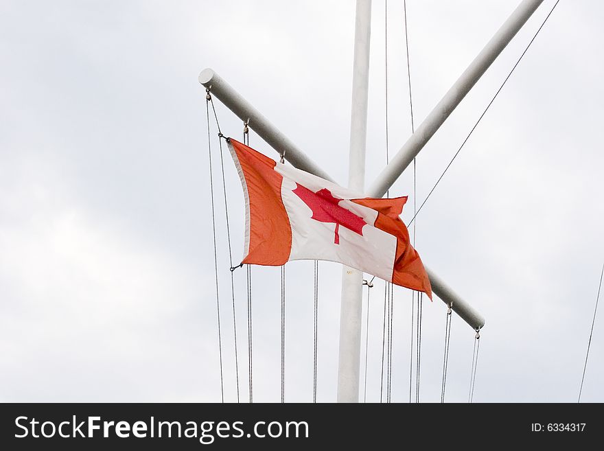 A ships mast flying a Canadian flag. A ships mast flying a Canadian flag