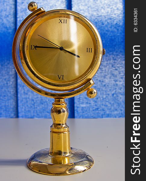 Golden table clock with blue background