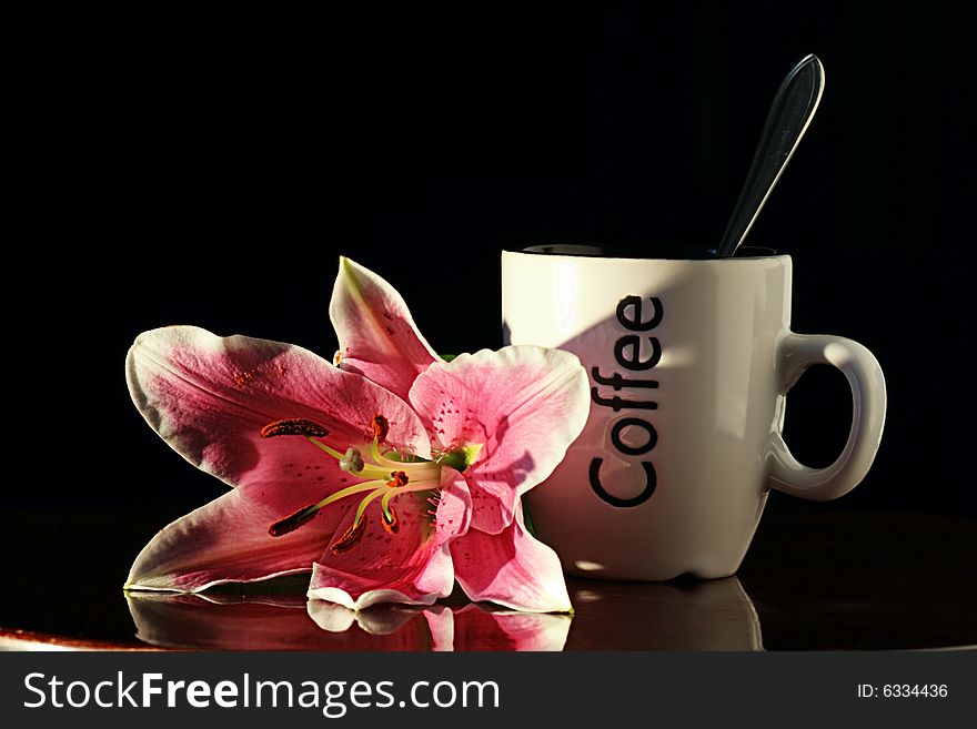 Pink lily and cup with coffee