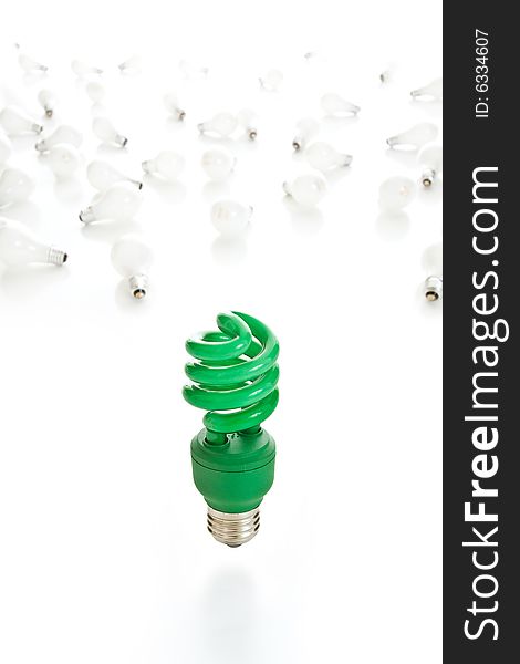 Bright green compact fluorescent light bulb in sharp focus with old incandescent bulbs littering the white background. Bright green compact fluorescent light bulb in sharp focus with old incandescent bulbs littering the white background.