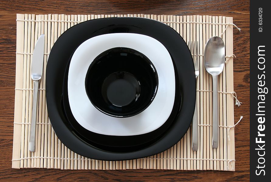 A black & white plates with utensils. A black & white plates with utensils