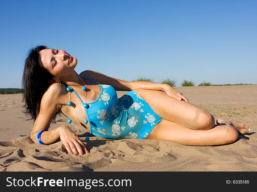 Beautiful girl in swimsuit relaxing on the beach