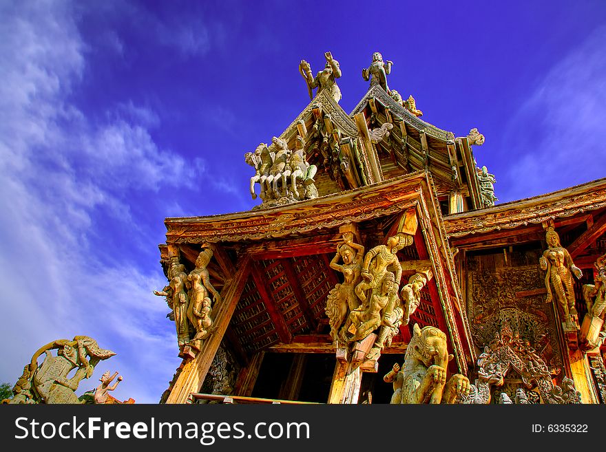 In Thailand in the city of Pattaya the sanctuary of truth is a wooden construction high of 105 meter covered with wooden carved sculpture; view of the sculpted roof. In Thailand in the city of Pattaya the sanctuary of truth is a wooden construction high of 105 meter covered with wooden carved sculpture; view of the sculpted roof