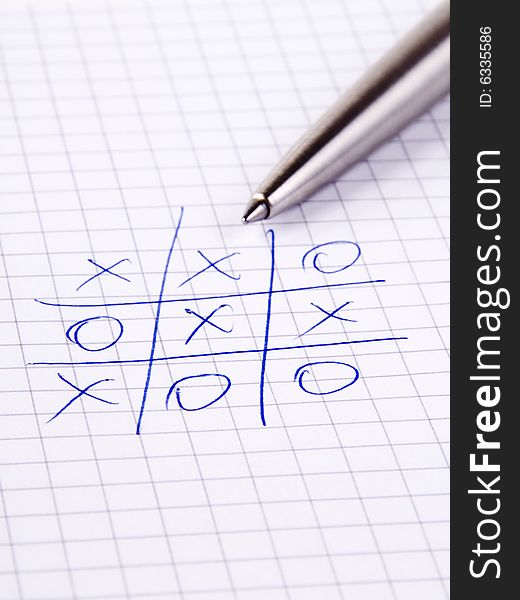 Tic Tac Toe known also as Noughts And Crosses and silver pen on notebook. Tic Tac Toe known also as Noughts And Crosses and silver pen on notebook