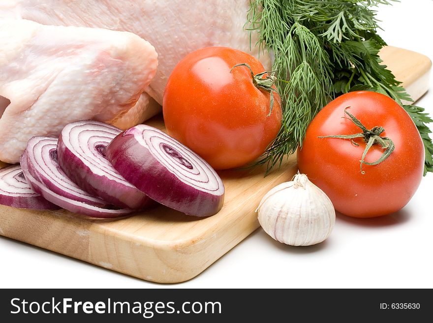 Fresh chicken with vegetables on a white background. Close up.