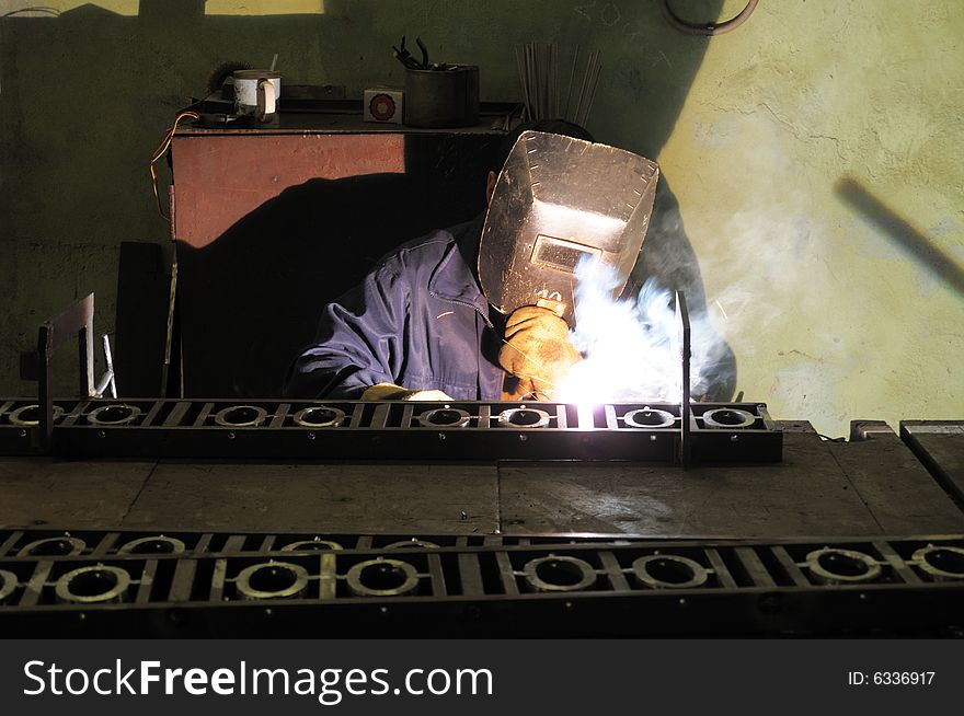 Welder works with a lattice of city park.