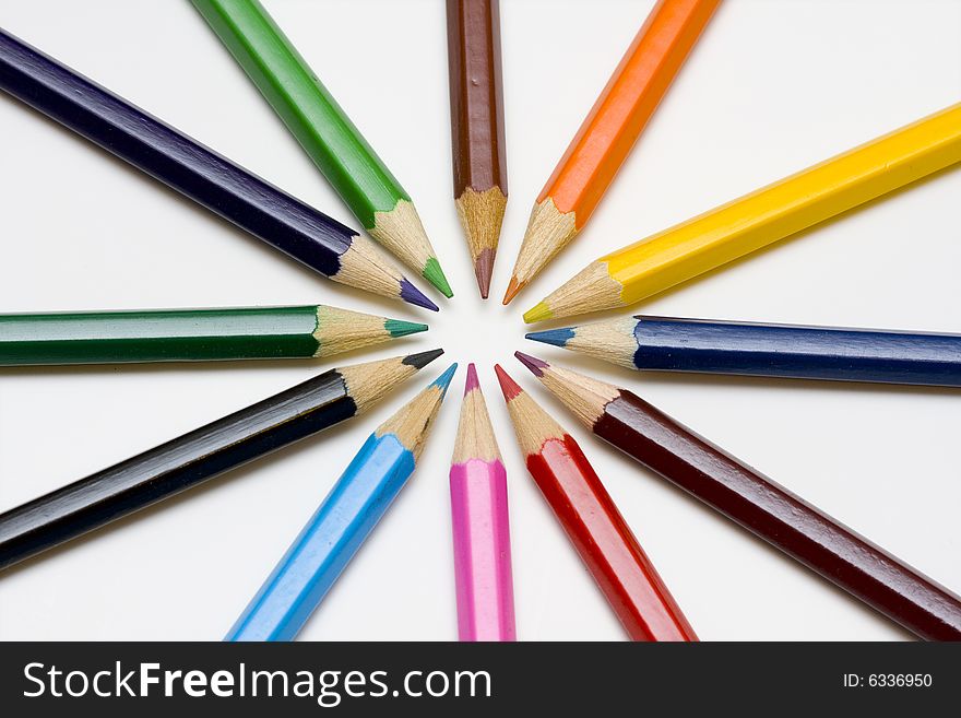 Color pencils in arrange in color wheel colors on white background