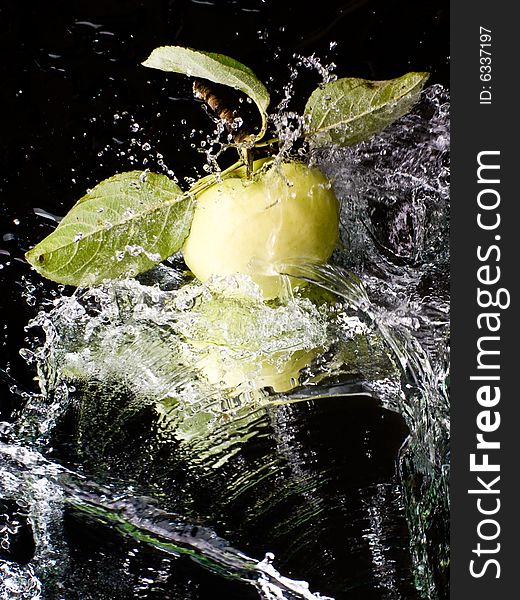 Fresh apple with water splashes on a mirror surface. Fresh apple with water splashes on a mirror surface