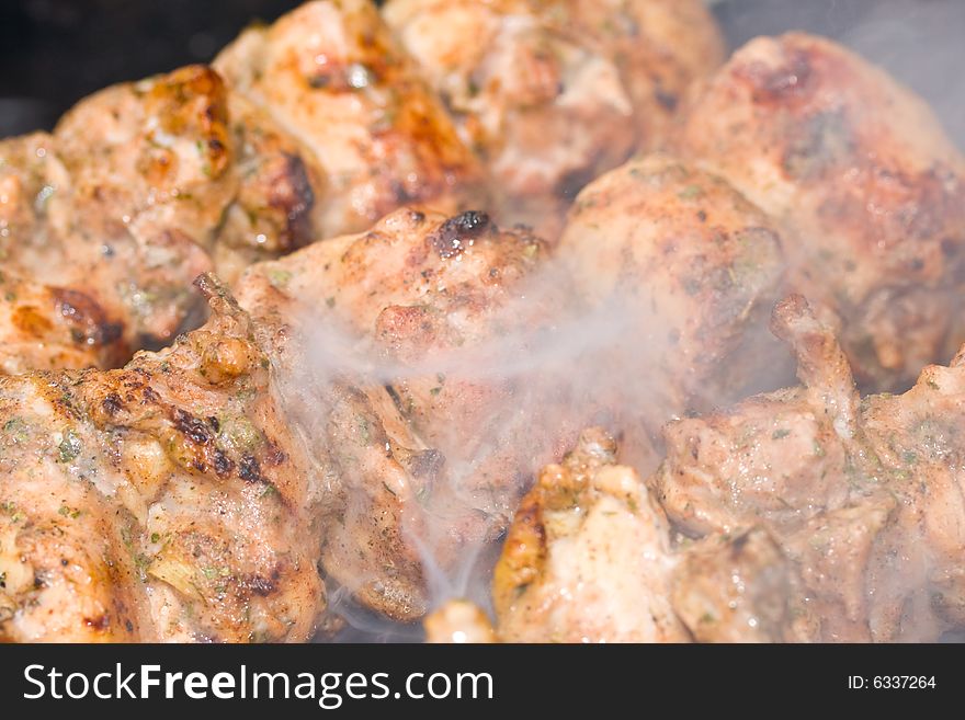 Shish kebab preparation on a brazier. Outdoor picnic. Close up.