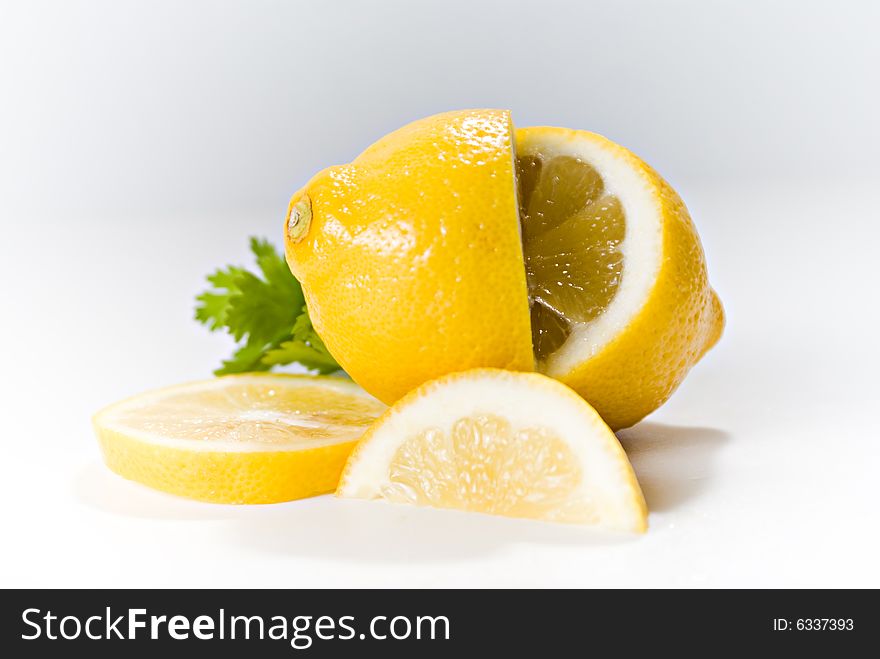 Lemons, whole and sliced, arranged on a white background.